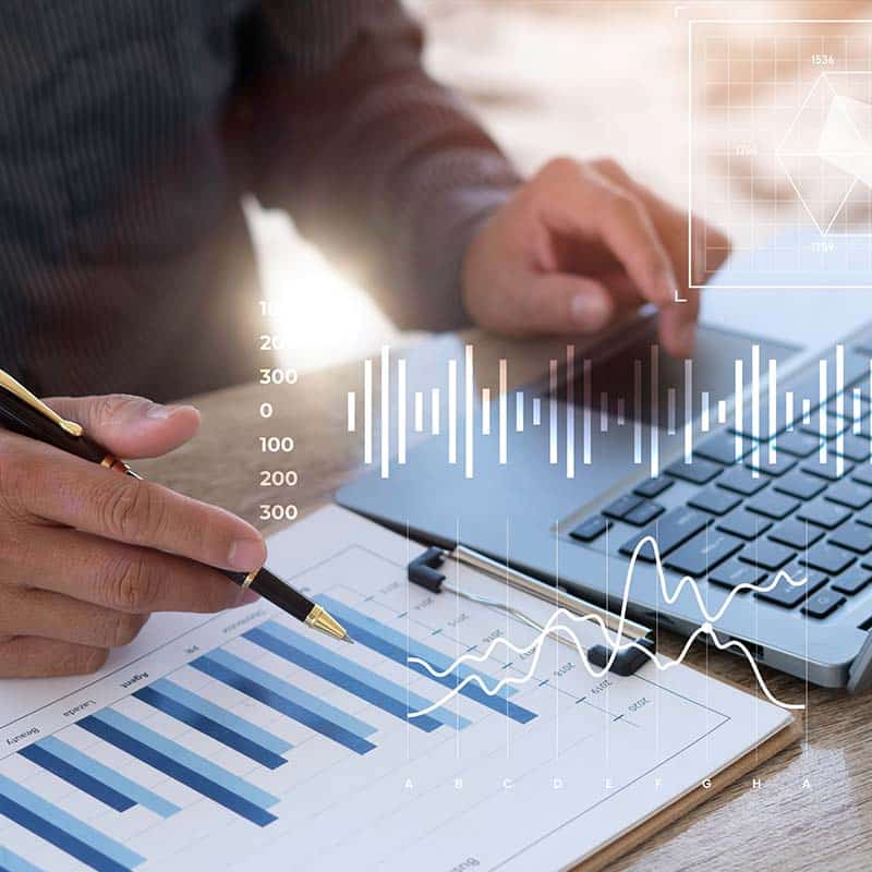 Person using a laptop and making notes
